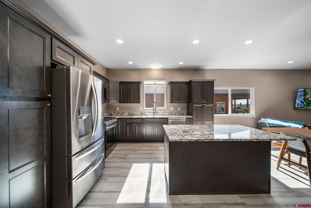 449 Birch St, Bayfield, CO 81122 - kitchen featuring stainless steel appliances, dark brown cabinetry, a center island, light wood-style floors, and light stone countertops