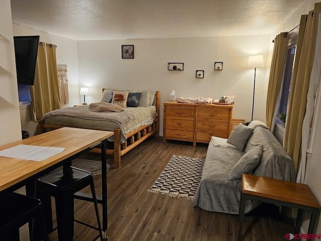 bedroom with dark wood-type flooring and a textured ceiling