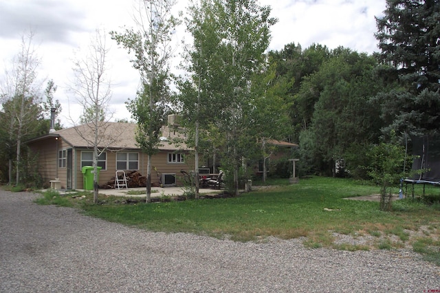 view of front of home featuring a trampoline and a front yard