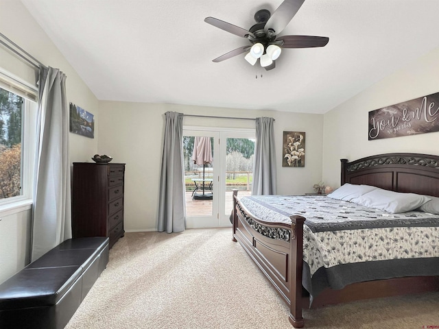 carpeted bedroom with access to outside, ceiling fan, multiple windows, and lofted ceiling