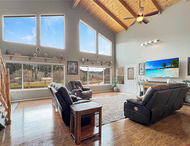 living room featuring beamed ceiling, hardwood / wood-style flooring, high vaulted ceiling, and ceiling fan