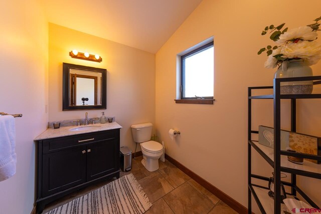 bathroom featuring vanity, vaulted ceiling, toilet, and tile patterned floors