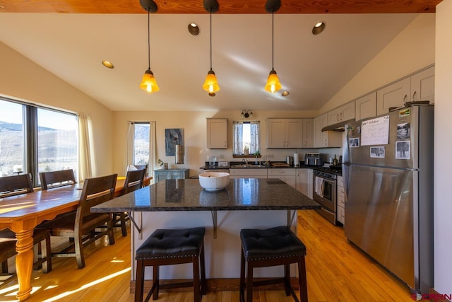 kitchen with a center island, light hardwood / wood-style flooring, decorative light fixtures, gray cabinets, and appliances with stainless steel finishes