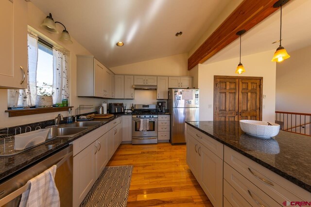 kitchen with appliances with stainless steel finishes, lofted ceiling with beams, decorative light fixtures, and sink