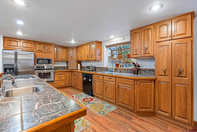 kitchen featuring sink, light wood-type flooring, and appliances with stainless steel finishes