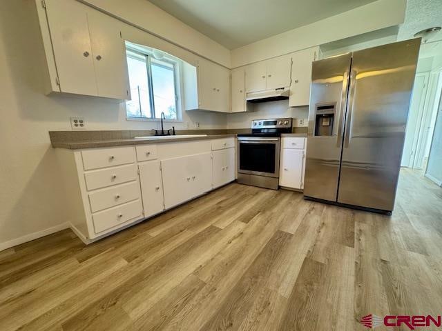 kitchen with sink, white cabinets, light hardwood / wood-style floors, and appliances with stainless steel finishes