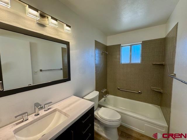 full bathroom featuring wood-type flooring, vanity, toilet, and tiled shower / bath