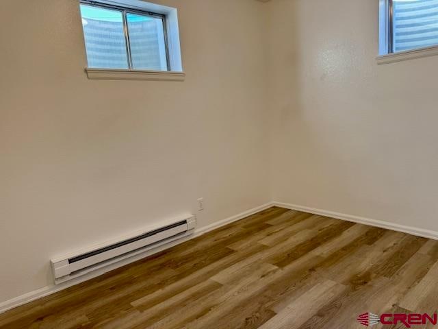 spare room featuring hardwood / wood-style floors and a baseboard radiator