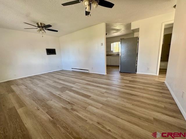 unfurnished living room with a textured ceiling, light wood-type flooring, ceiling fan, and a baseboard heating unit