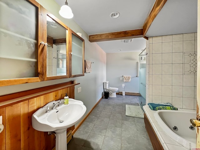 bathroom with sink, tile patterned flooring, a relaxing tiled tub, toilet, and beam ceiling