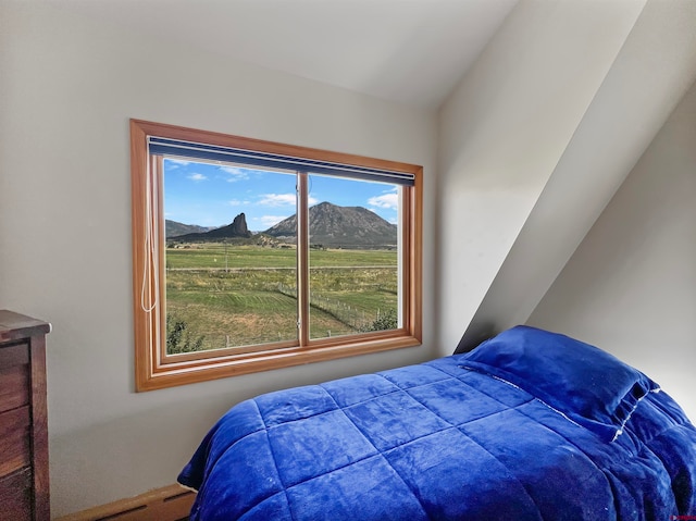 bedroom featuring a mountain view and vaulted ceiling