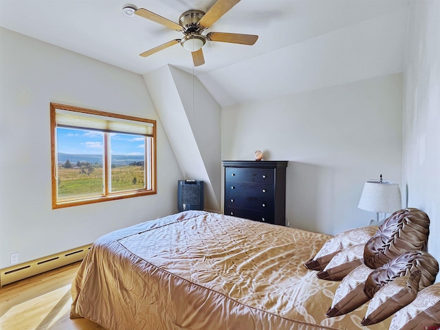 bedroom with ceiling fan, a baseboard radiator, wood-type flooring, and lofted ceiling