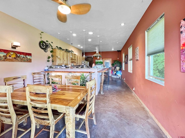 dining space with ceiling fan, light tile patterned floors, and a textured ceiling