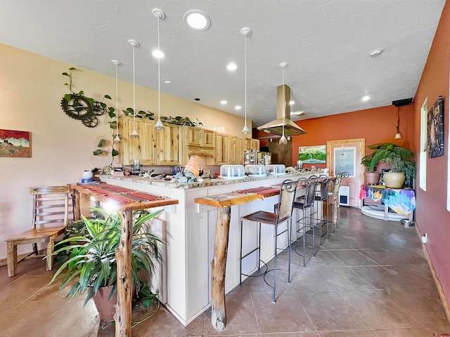 kitchen with kitchen peninsula, a kitchen breakfast bar, light brown cabinets, tile patterned flooring, and hanging light fixtures