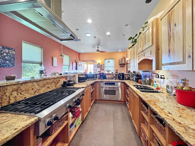 kitchen featuring pendant lighting, a wealth of natural light, kitchen peninsula, and appliances with stainless steel finishes