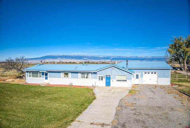 single story home featuring a mountain view, a garage, and a front lawn