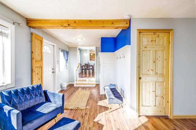 interior space featuring beamed ceiling, a textured ceiling, and hardwood / wood-style flooring