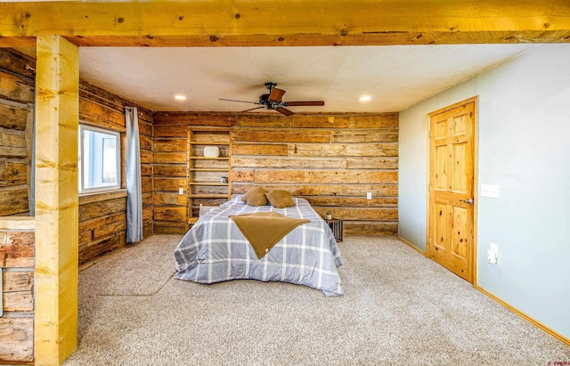 bedroom with carpet floors, rustic walls, and ceiling fan