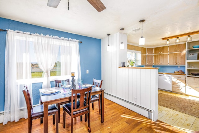 dining area with baseboard heating, ceiling fan, and light hardwood / wood-style flooring