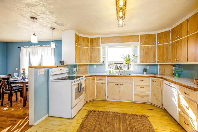 kitchen with white appliances, sink, decorative light fixtures, light hardwood / wood-style flooring, and tile counters