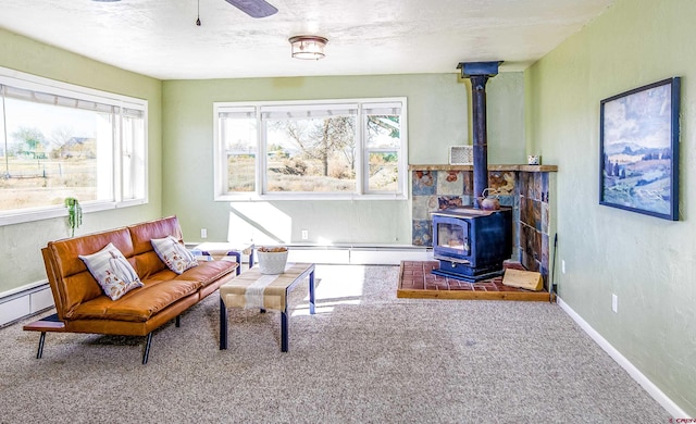 living area featuring carpet, a wood stove, and a textured ceiling