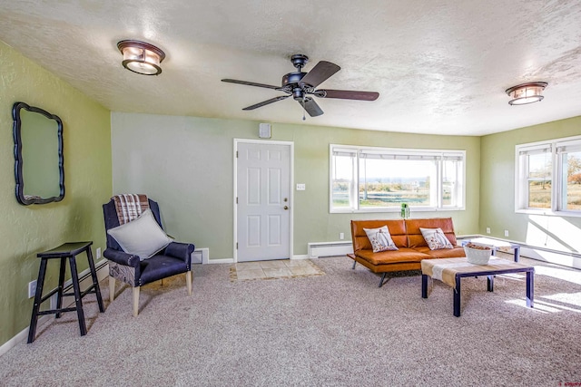 sitting room with a textured ceiling, light colored carpet, ceiling fan, and a baseboard heating unit