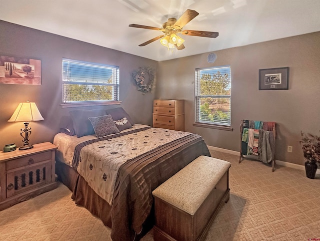 bedroom featuring multiple windows, ceiling fan, and light colored carpet