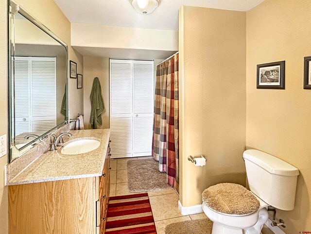 bathroom with tile patterned flooring, vanity, and toilet