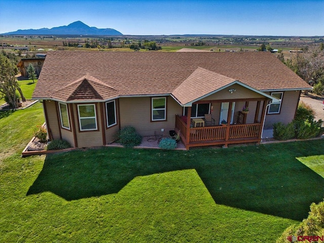 rear view of house featuring a lawn and a mountain view