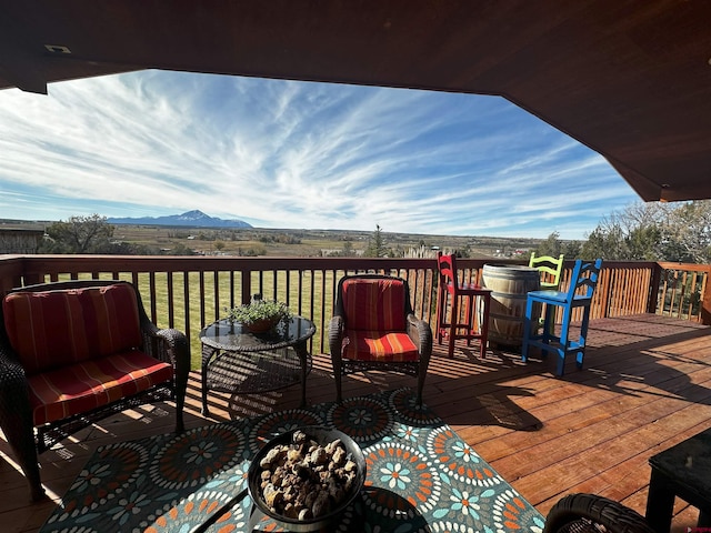 deck with a lawn and a mountain view