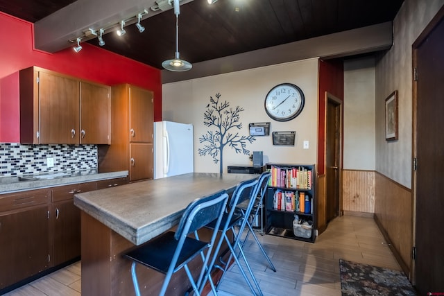 kitchen with a center island, rail lighting, light wood-type flooring, and white refrigerator