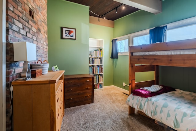 carpeted bedroom featuring rail lighting and wooden ceiling