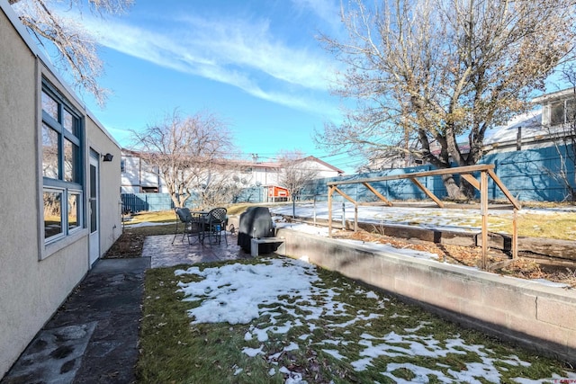 yard covered in snow with a patio area