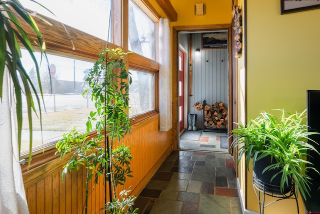 corridor featuring a wealth of natural light and wooden walls