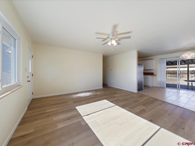 unfurnished living room featuring light hardwood / wood-style flooring and ceiling fan