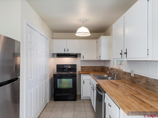 kitchen featuring white cabinets, stainless steel appliances, hanging light fixtures, and range hood