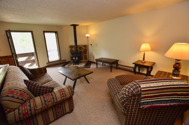 carpeted living room with a wood stove, a textured ceiling, and baseboard heating