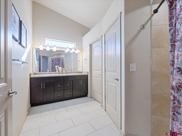 bathroom with tile patterned floors, vanity, lofted ceiling, and walk in shower