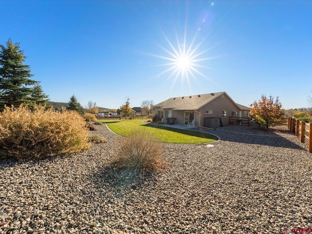 rear view of property featuring a patio area and a yard