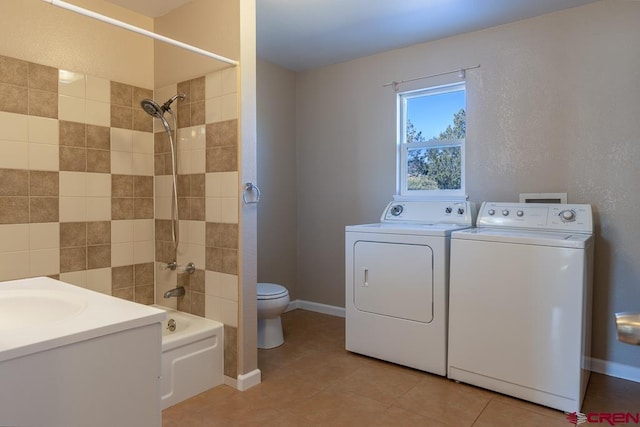 clothes washing area with light tile patterned floors, separate washer and dryer, and sink