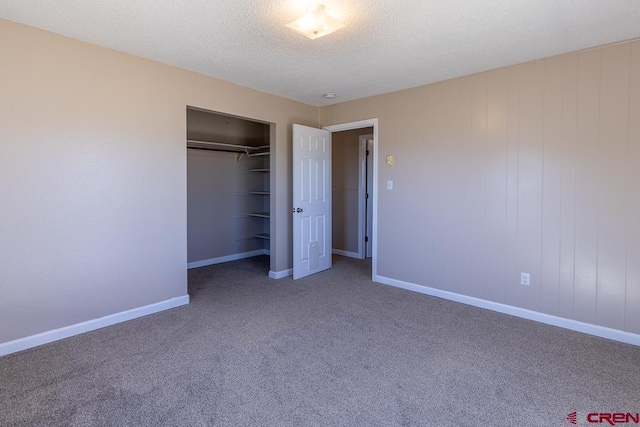 unfurnished bedroom featuring carpet flooring, a textured ceiling, and a closet