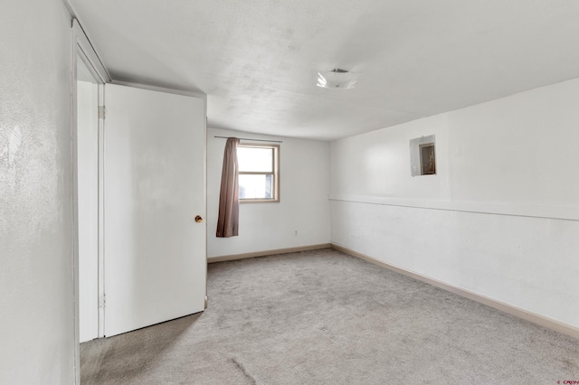 spare room featuring light carpet and a textured ceiling