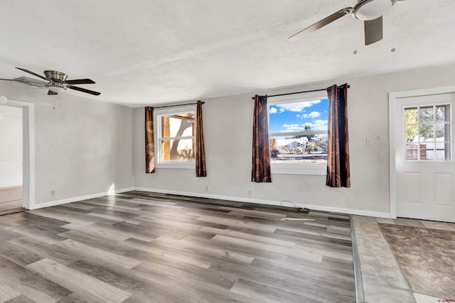 unfurnished room with a textured ceiling, hardwood / wood-style flooring, and ceiling fan