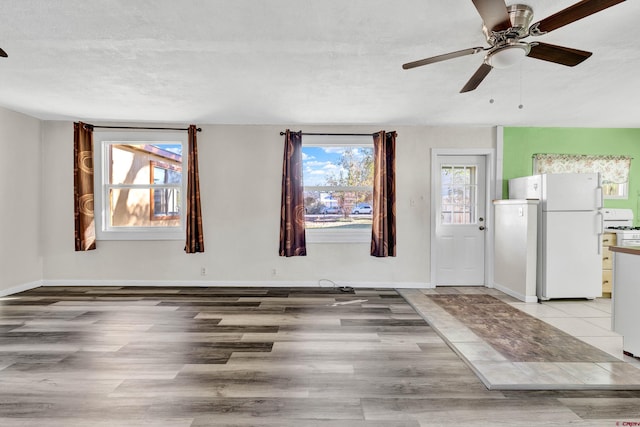 interior space with ceiling fan, plenty of natural light, a textured ceiling, and hardwood / wood-style flooring