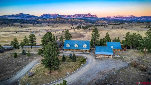 aerial view at dusk with a mountain view and a rural view