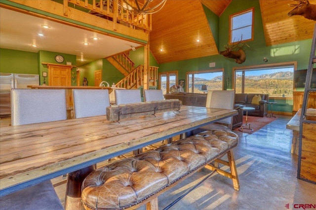 dining room featuring wooden ceiling, high vaulted ceiling, and concrete floors