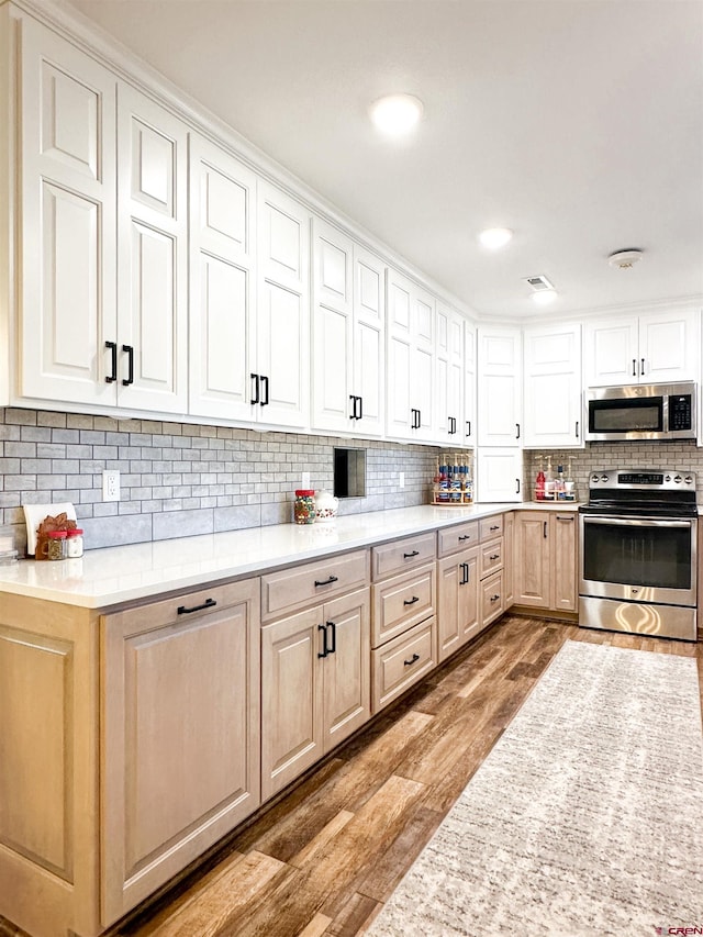 kitchen featuring tasteful backsplash, light hardwood / wood-style flooring, and stainless steel appliances