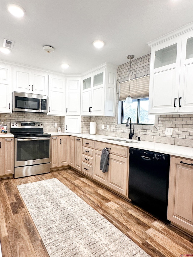 kitchen featuring white cabinetry, hardwood / wood-style floors, stainless steel appliances, and sink