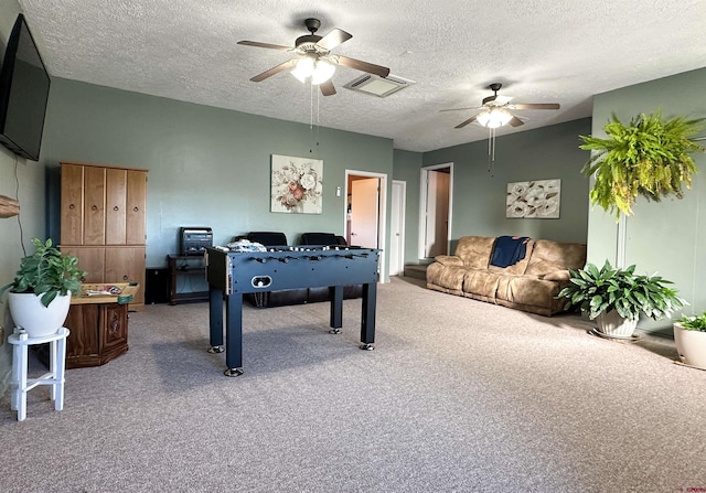 recreation room with carpet flooring, ceiling fan, and a textured ceiling