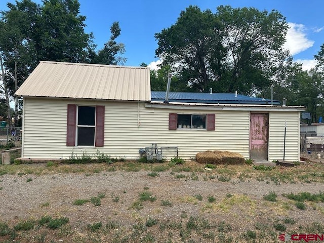 rear view of property with solar panels